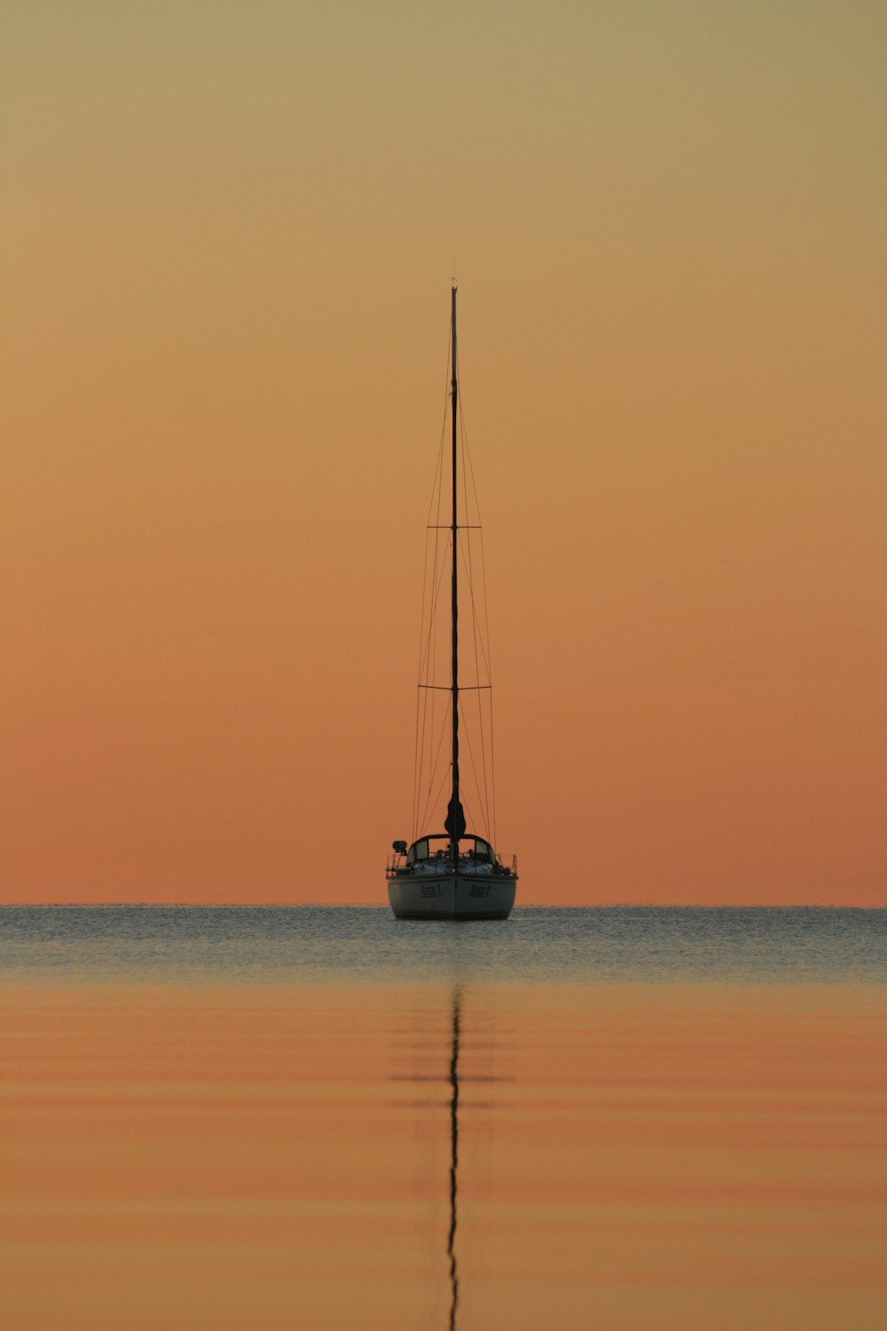 Barco blanco y negro en el cuerpo de agua durante la hora dorada