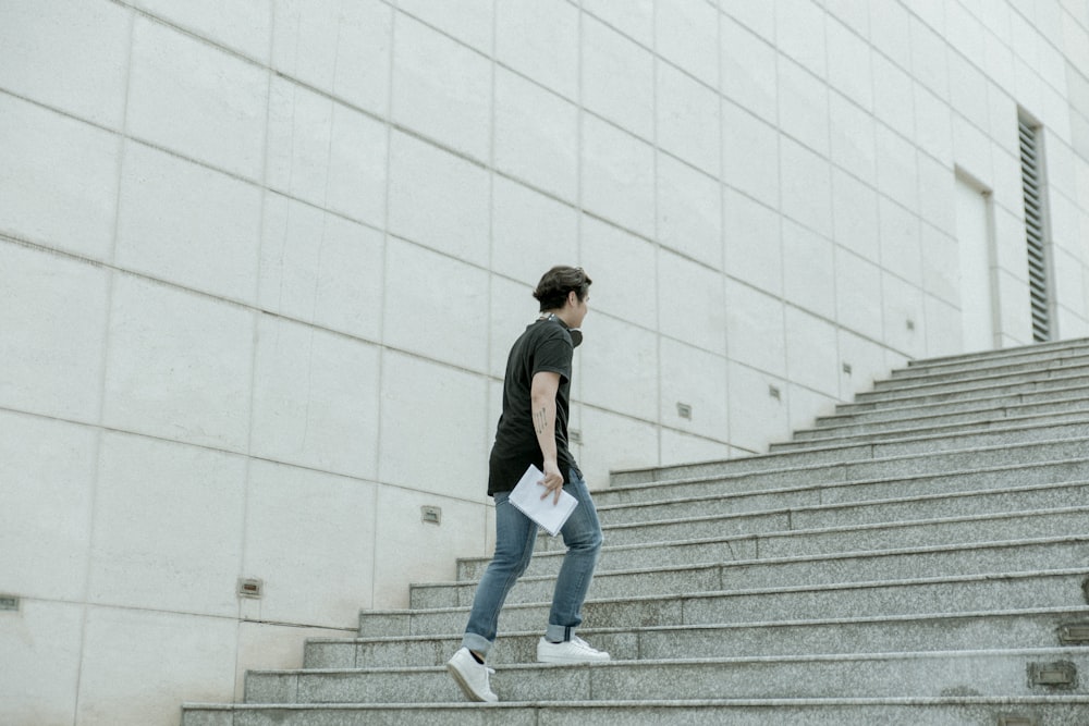 흰 담요 종이를 들고 회색 계단을 걷는 남자
