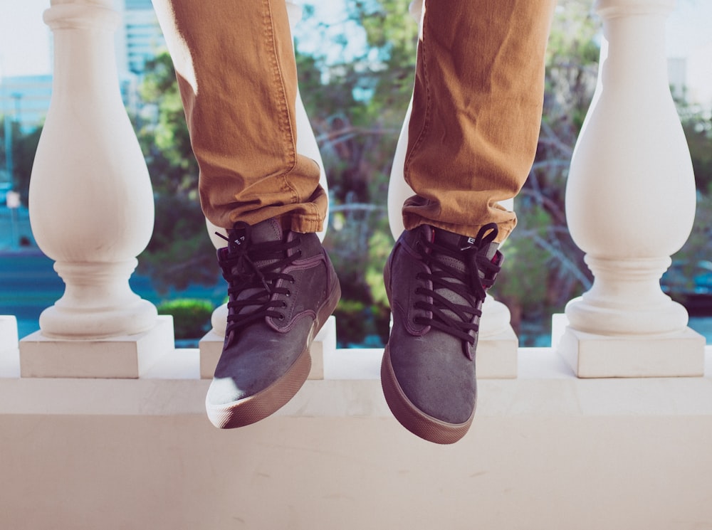 person sitting on concrete fence