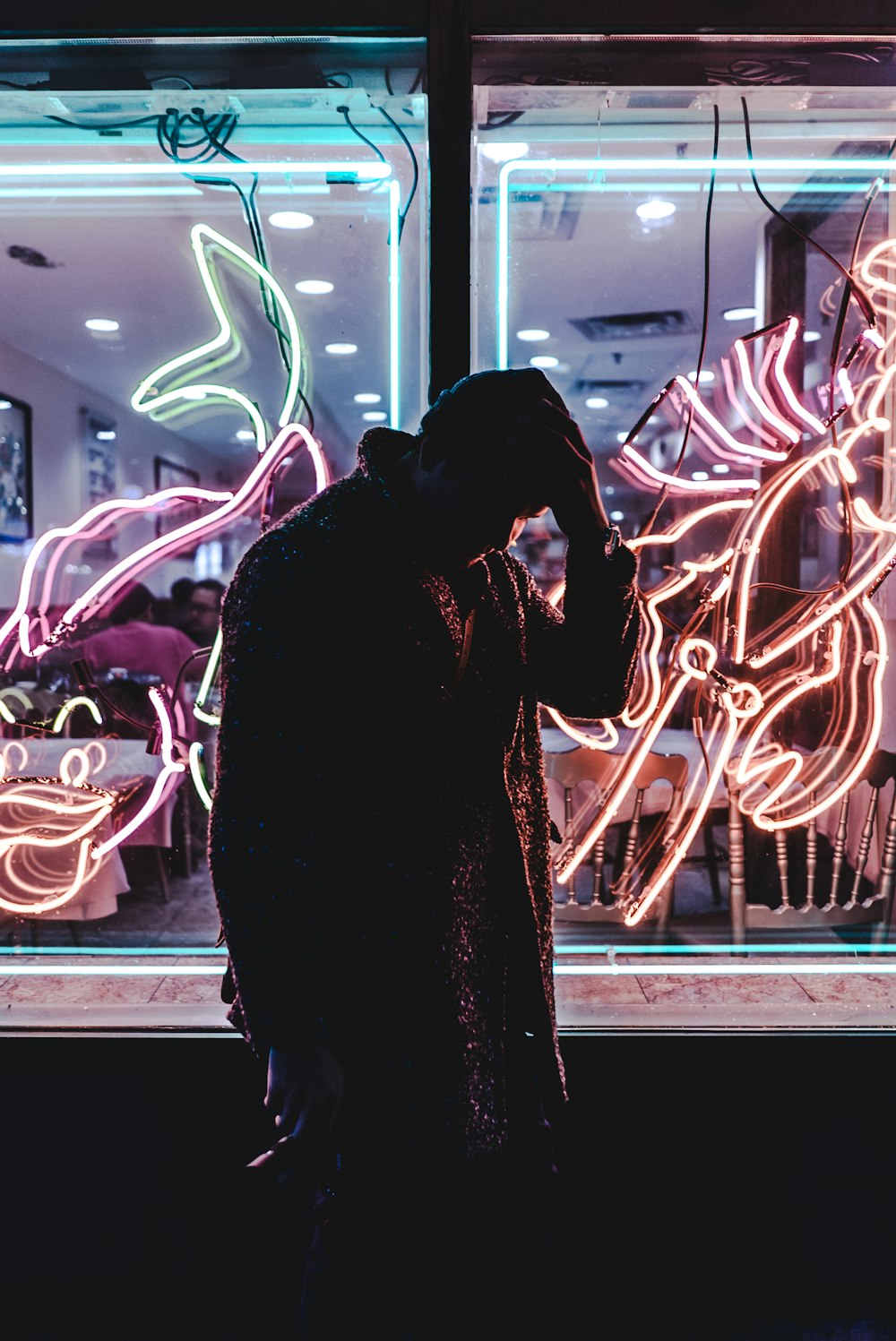 man standing holding his head beside building