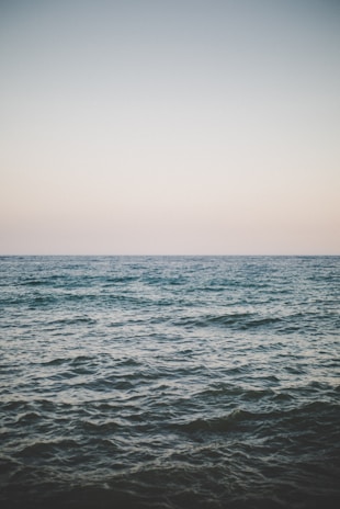 A serene ocean view with gentle waves under a clear blue sky.