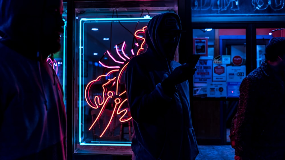 man standing holding smartphone