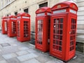 lined-up red telephone booths near building