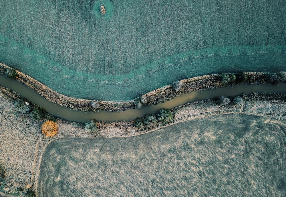 areal photography of river between grass fields