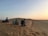 A group of friends enjoying a sunset view from a desert landscape.