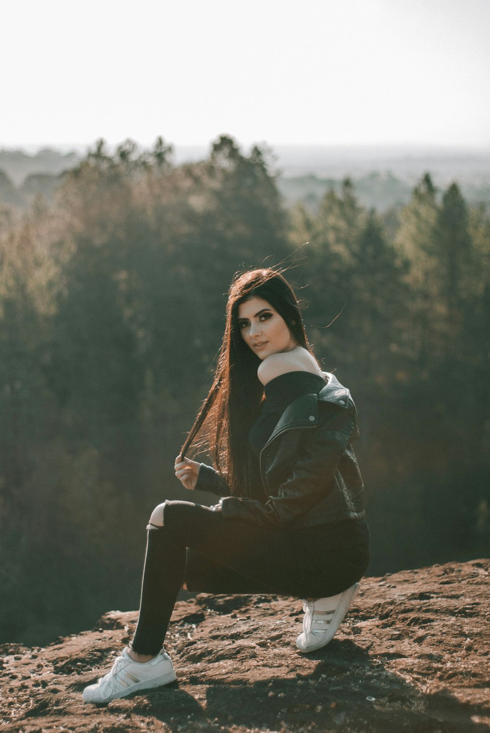 Femme debout sur la montagne brune pendant la journée