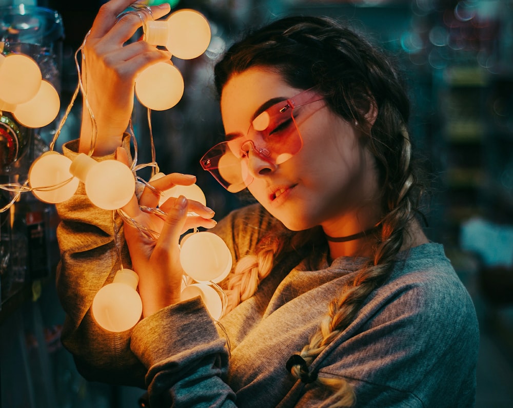 donna che indossa una camicia grigia a maniche lunghe che tiene la luce