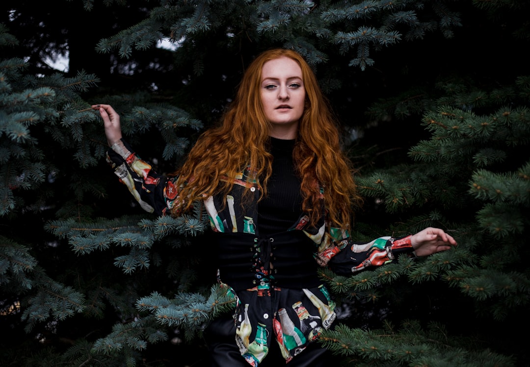 woman in black long-sleeved top beside trees