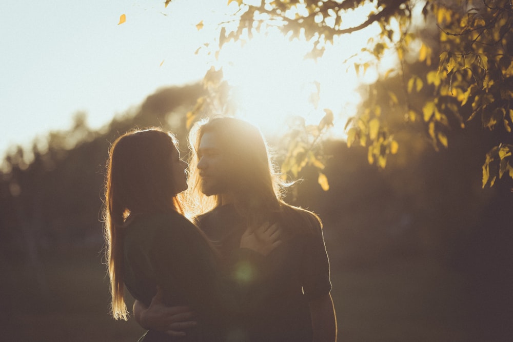 man with long hair holding a girl by her waist outdoors