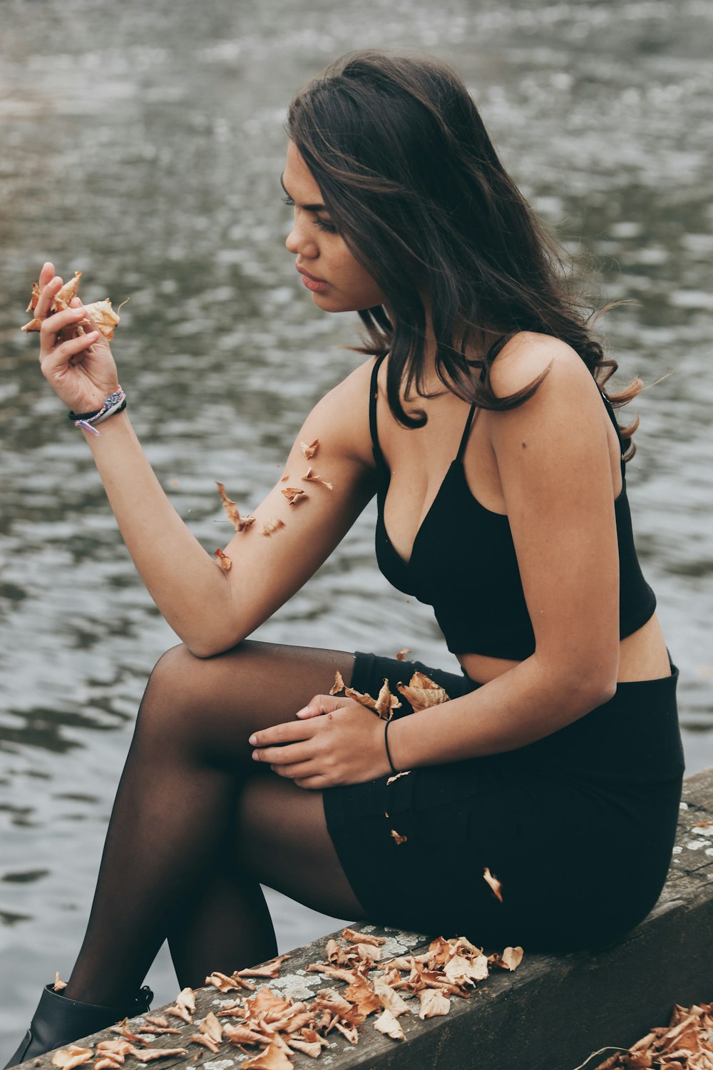 woman sitting next to body of water