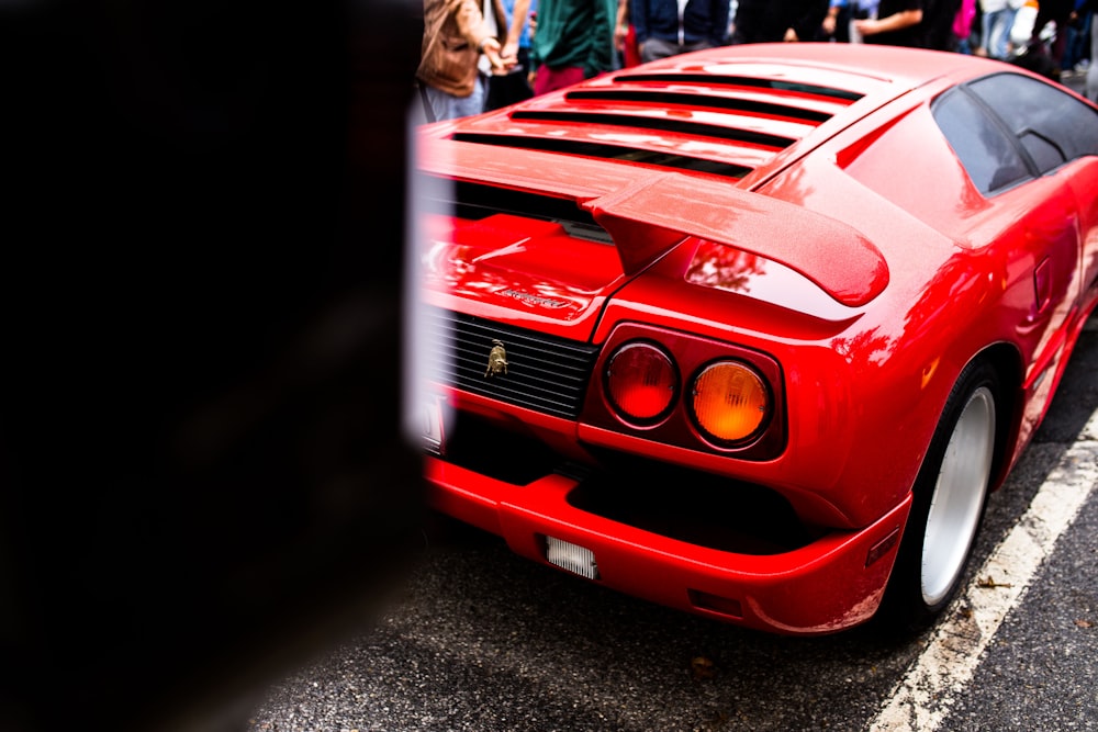 red luxury car parked on concrete road