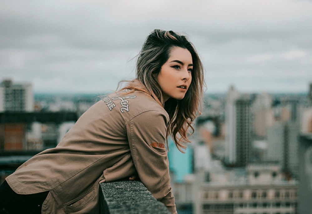 Photo de mise au point sélective d’une femme debout sur le toit d’un immeuble pendant la journée