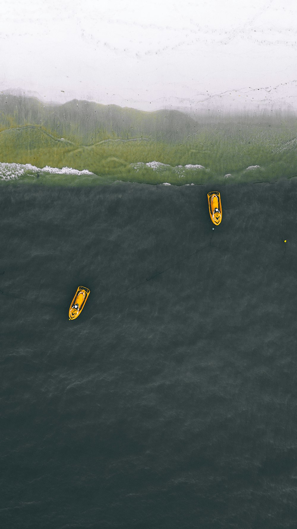two yellow personal watercraft on water