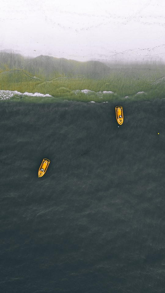 two yellow personal watercraft on water in Batu Ferringhi Beach Malaysia