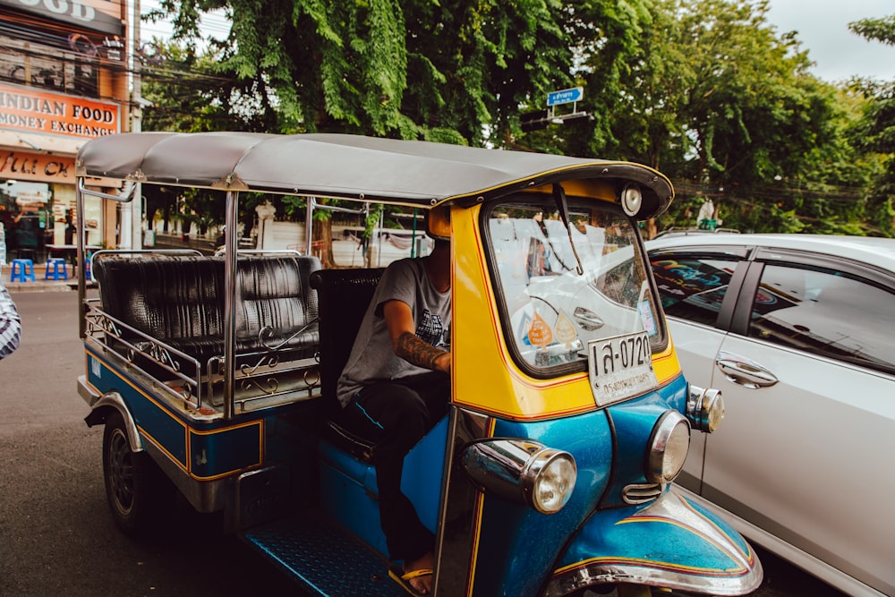 blue and yellow electric rickshaw