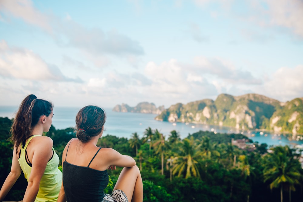 two women sitting on hilltop