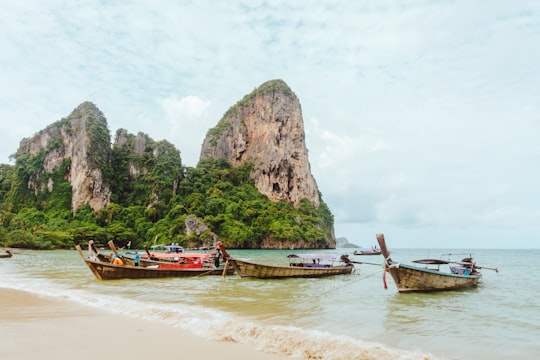 boats docked on seashore during daytime in Railay Beach West Thailand