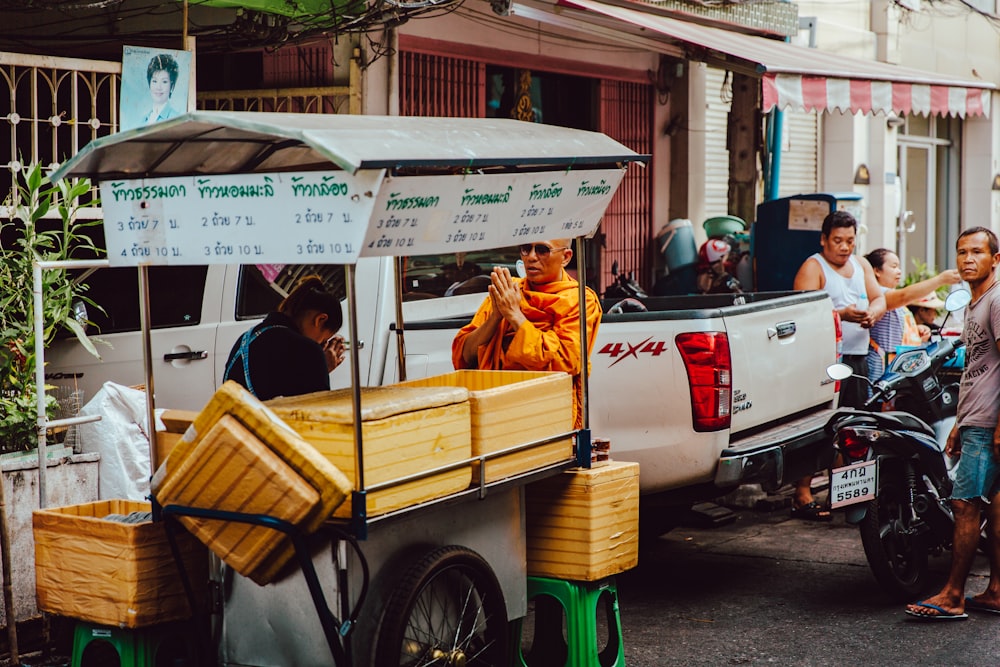 Monje frente a quiosco de comida cerca de camioneta