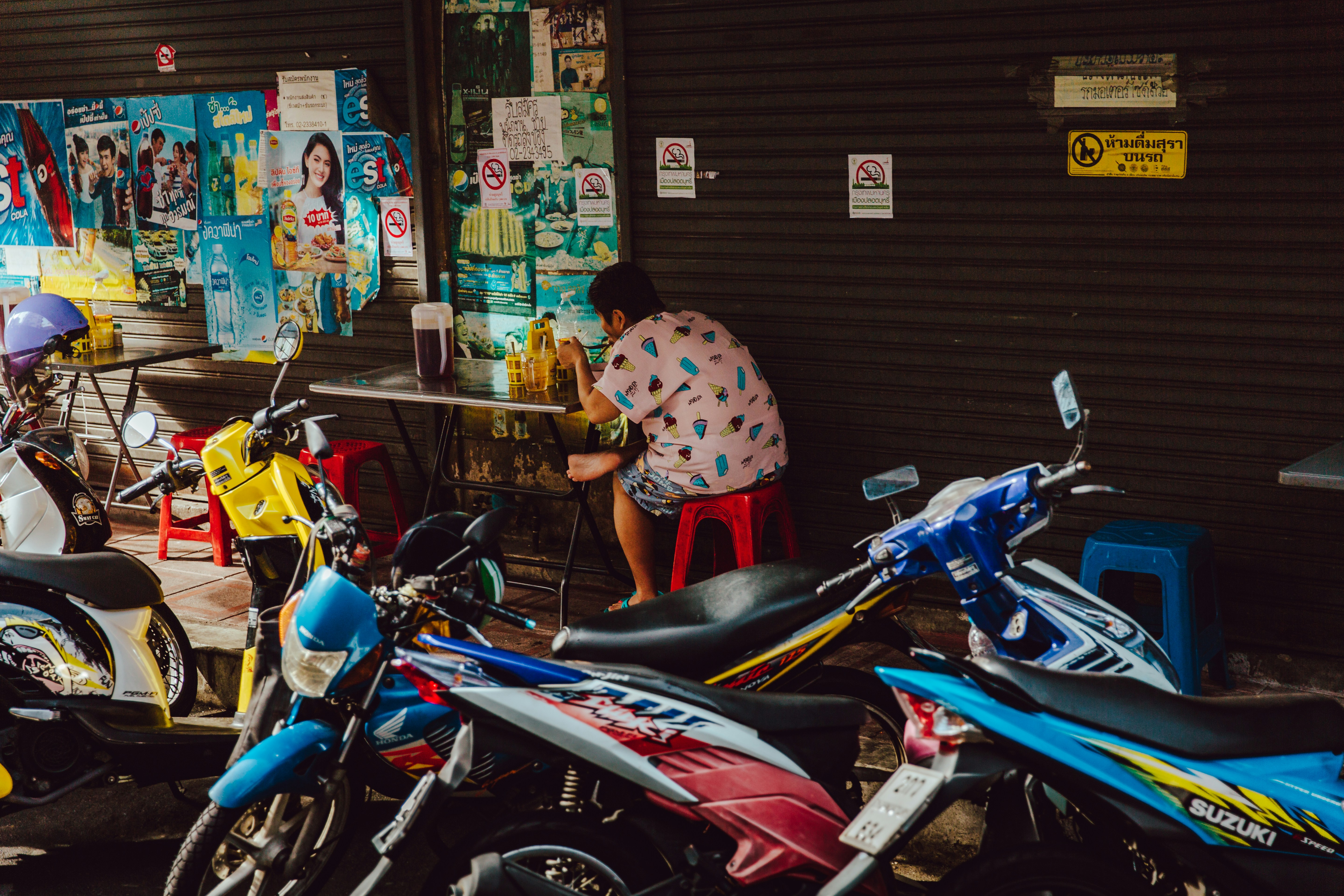 blue and white motor scooters near brown roller shutter