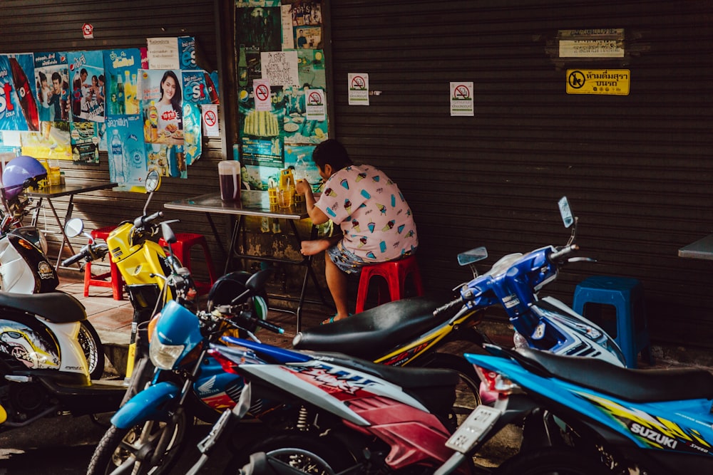 blue and white motor scooters near brown roller shutter