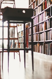 brown wooden stool near bookshelf