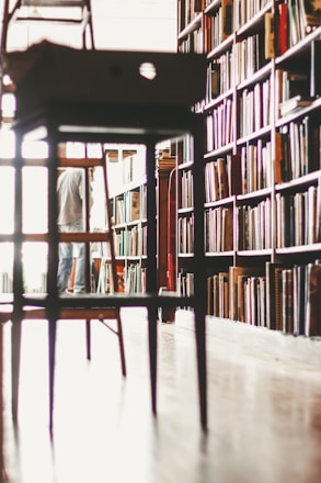 brown wooden stool near bookshelf
