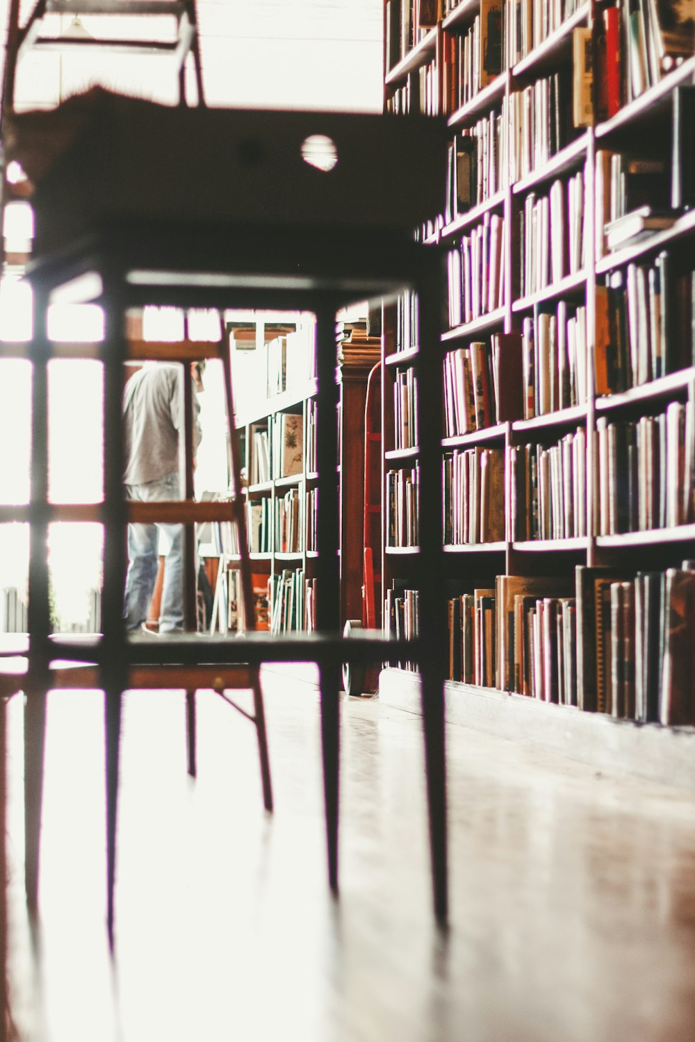 brown wooden stool near bookshelf