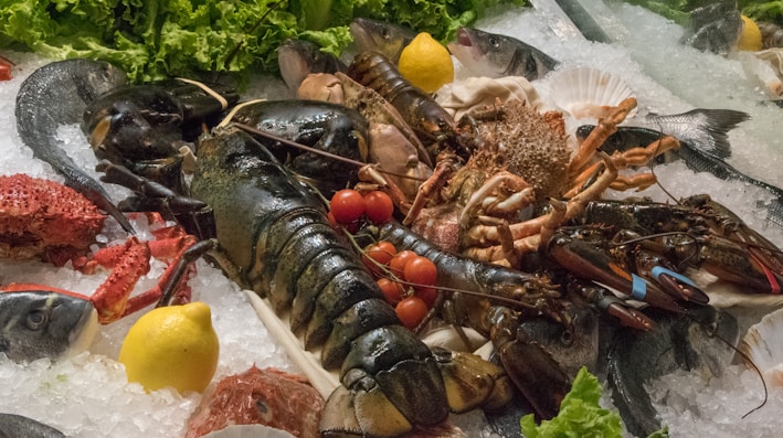 Close-up of glistening fresh lobsters on ice at a seafood market