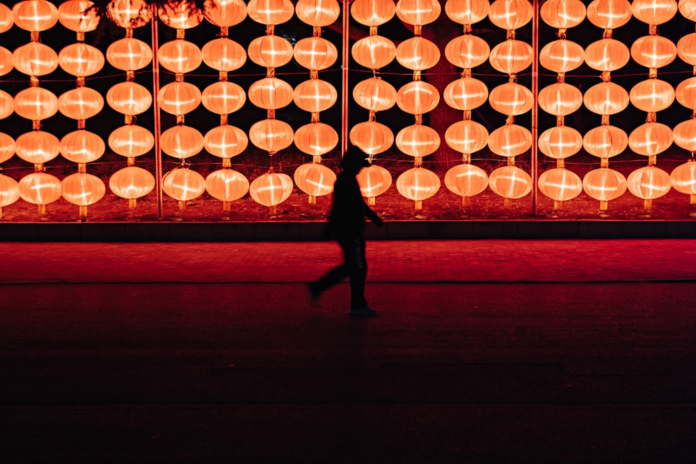 silhouette de personne marchant près de la lampe lanterne