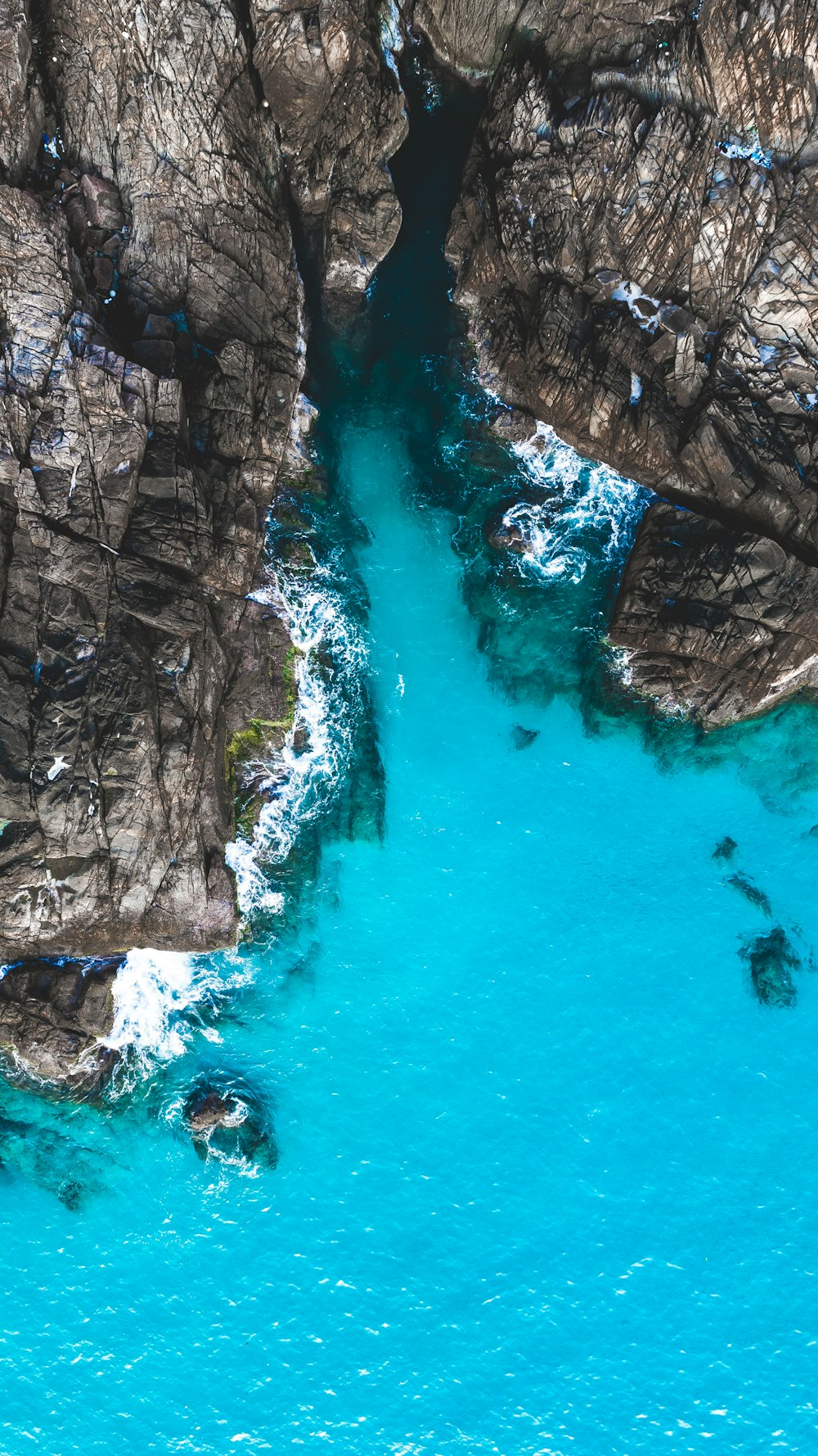 Photographie aérienne d’un plan d’eau à côté d’une falaise pendant la journée