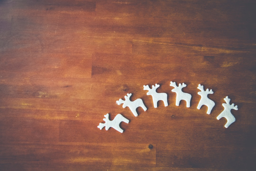 six white wooden deer decors on brown wooden surface