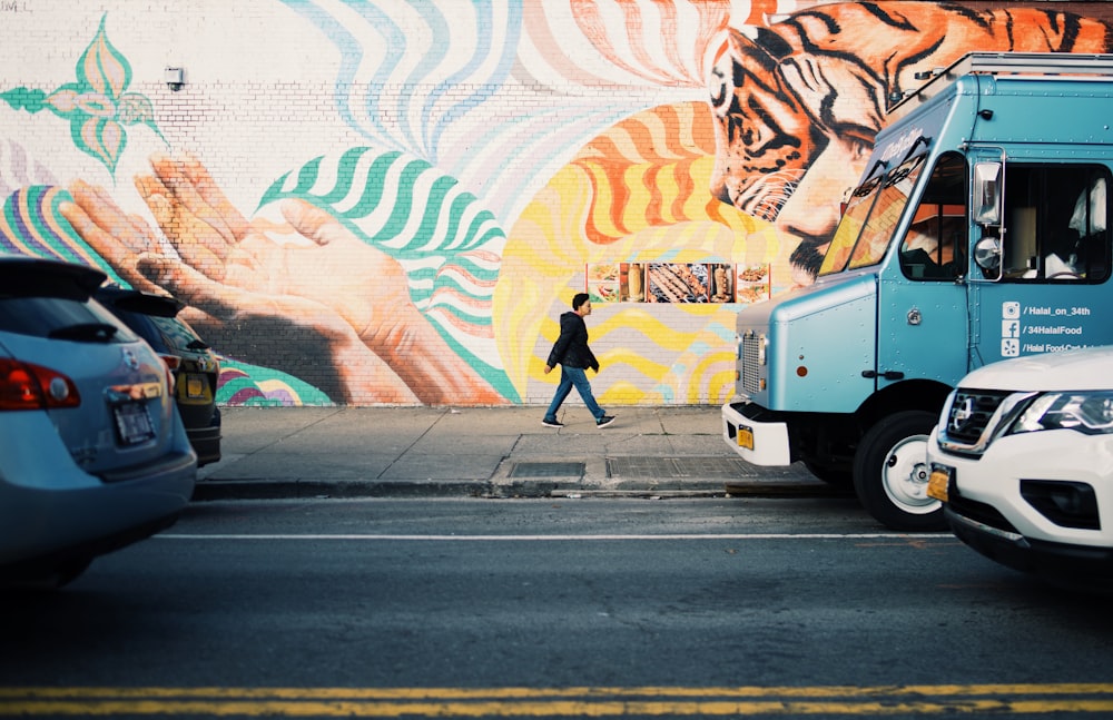 man walking on roadside during daytime