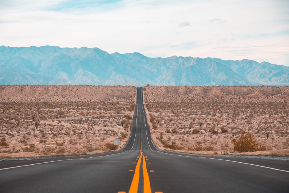 long exposure photography of black concrete road on open area during daytime