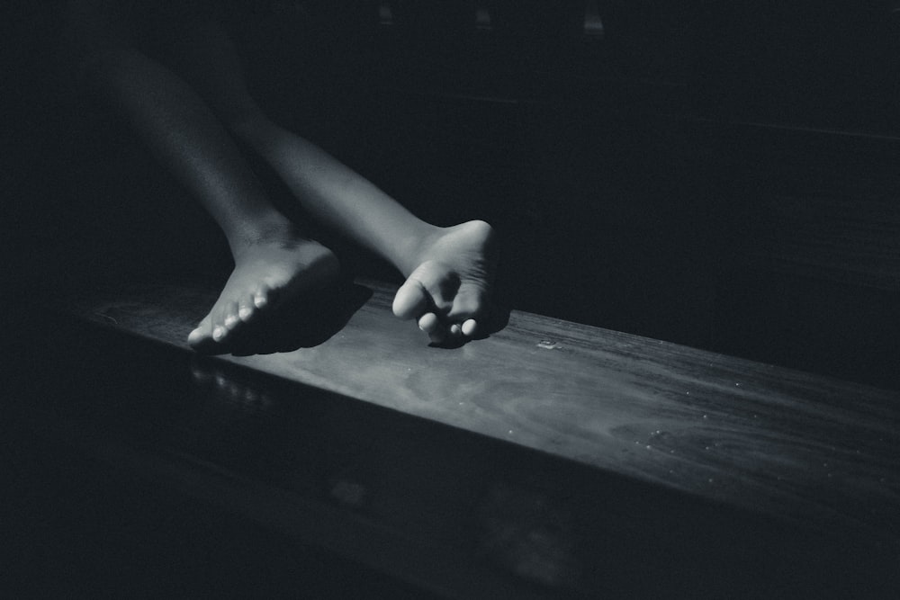 a black and white photo of a person's feet on a table
