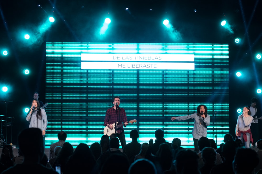 four people singing at stage