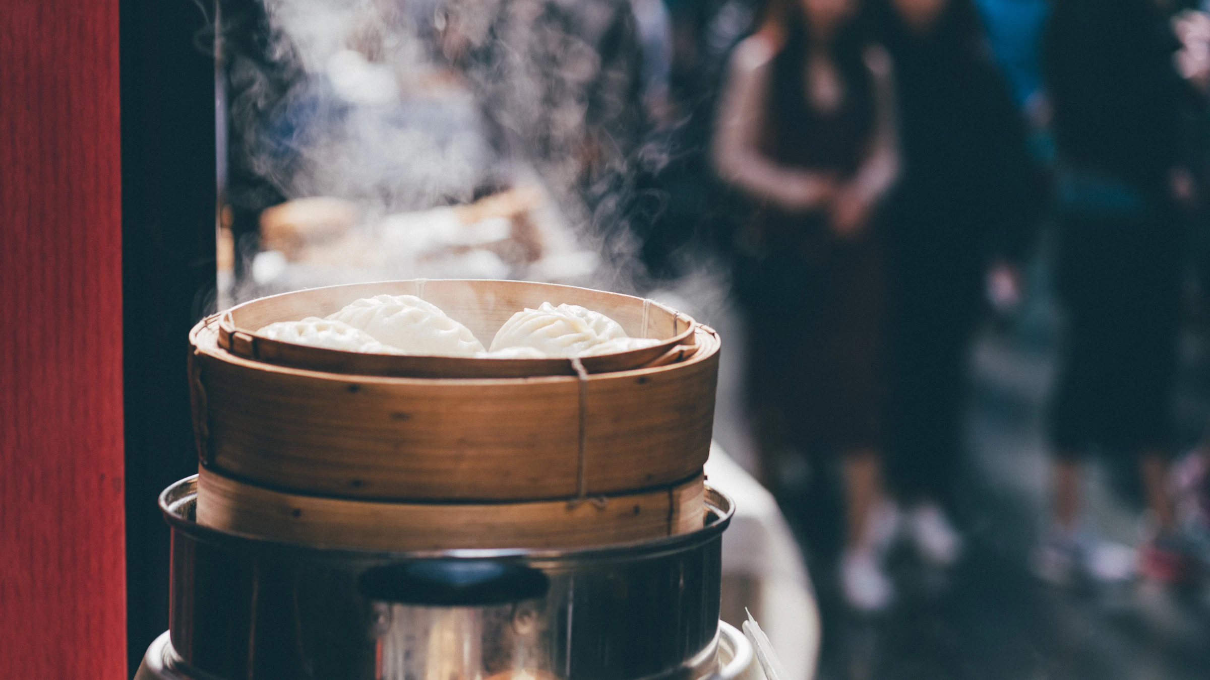 Steam rising from a bamboo steamer of momos