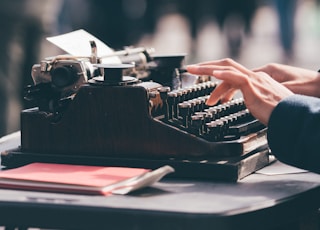 person using black typewriter