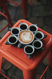 gray ceramic coffee mug set on top of red stool