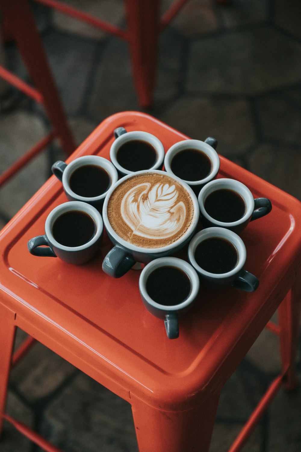 gray ceramic coffee mug set on top of red stool