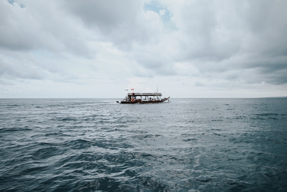 black boat floating on large body of water