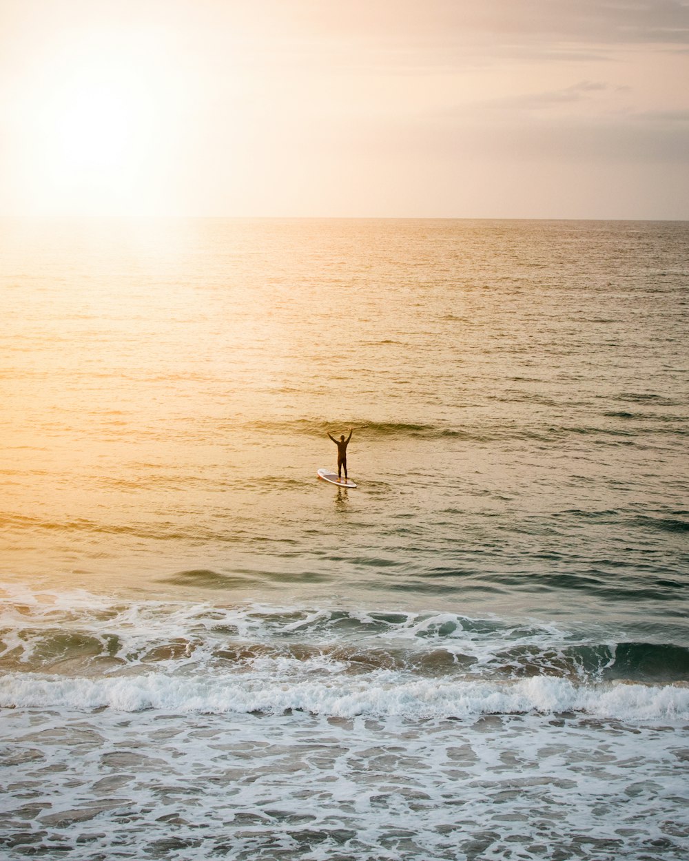 person standing on paddle board on body of water