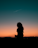 silhouette of woman standing under blue sky during golden hour