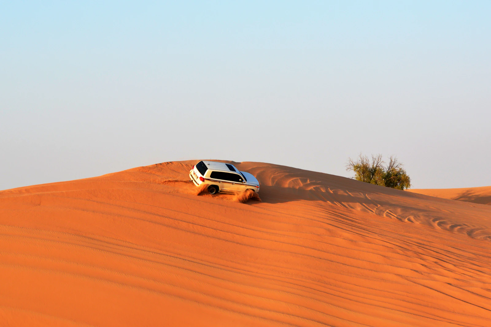 White 4x4 on red dunes in the desert near Abu Dhabi