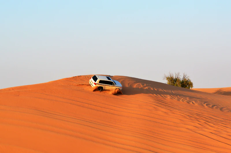White 4x4 on red dunes in the desert near Abu Dhabi