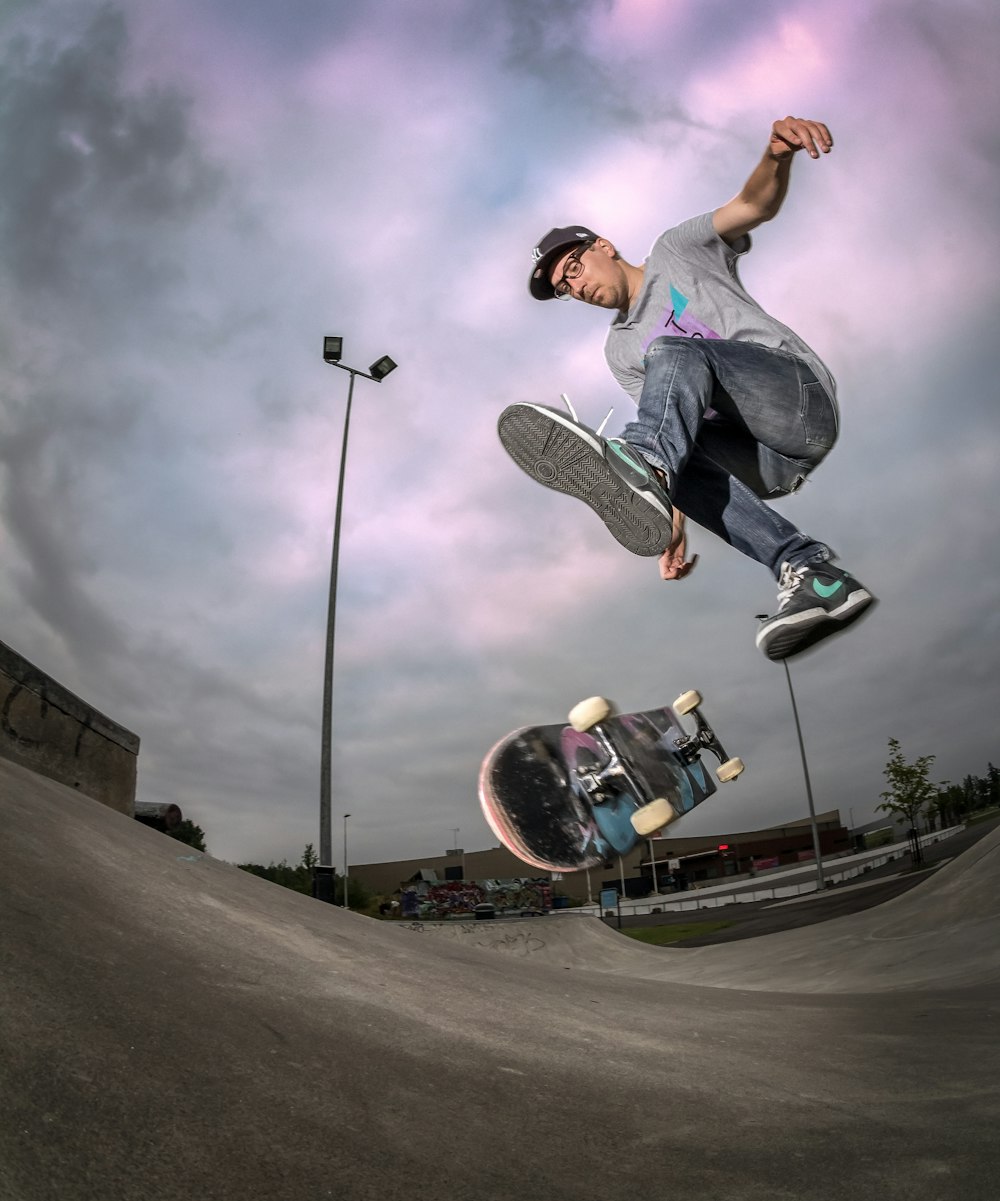 man in gray t-shirt and black pants playing skateboard