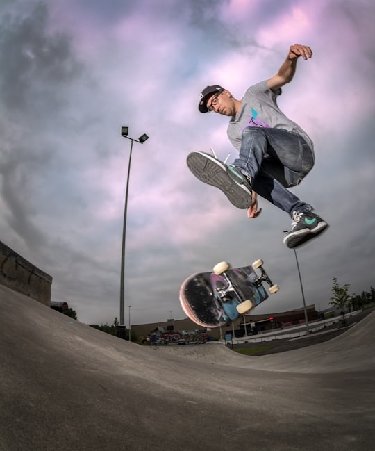 man in gray t-shirt and black pants playing skateboard in Helsinki Finland