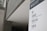 A sign in a modern building displays text in both English and Chinese. It provides directions to the Acquisition & Cataloguing Department, Compact Stacks, and Archives. The setting appears to be a university or a similar institutional environment with a sleek, minimalistic design.