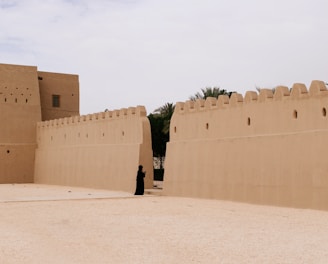 person wearing black clothes near beige wall during daytime