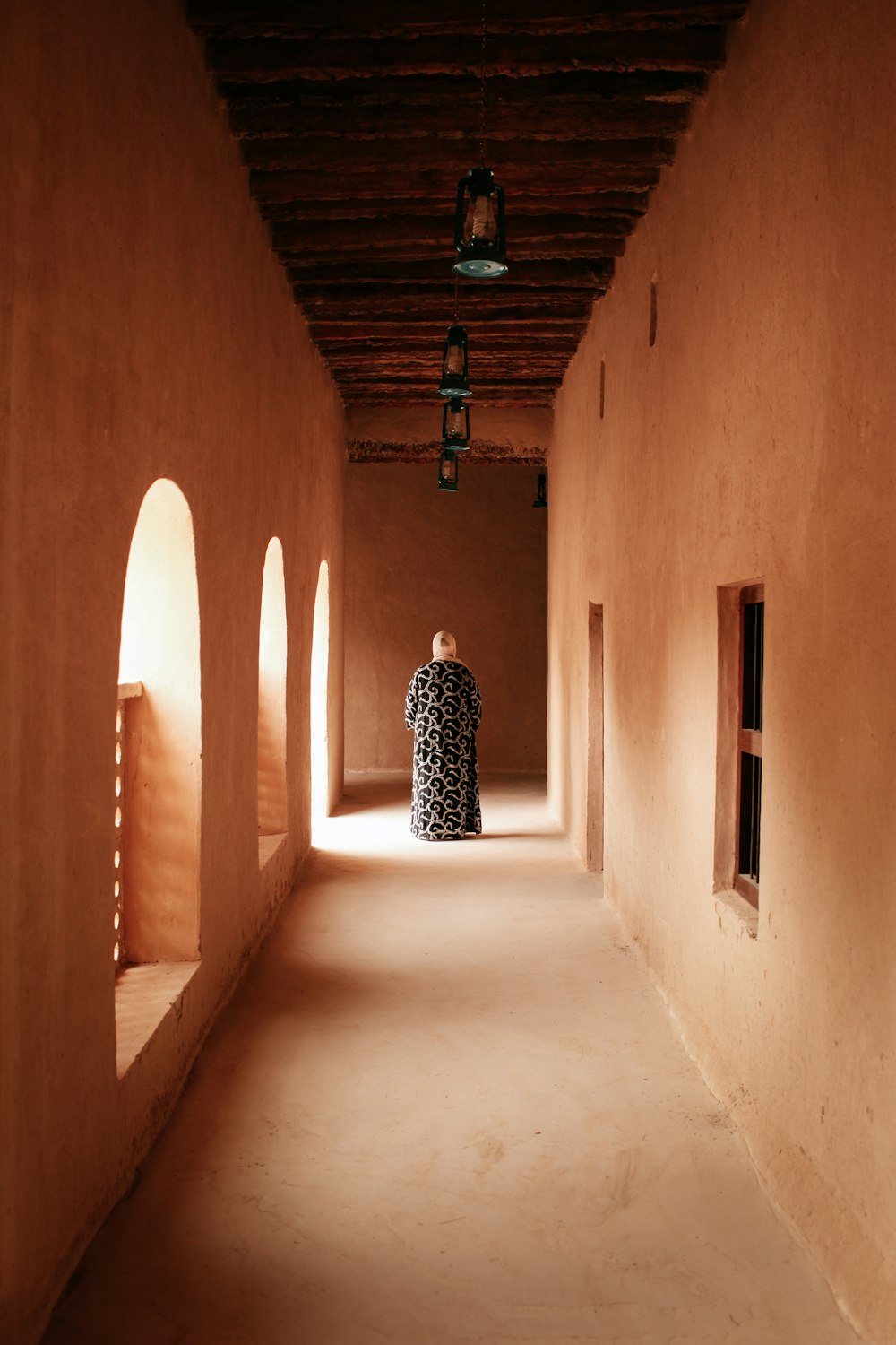 person wearing black and white dress walking on the halway