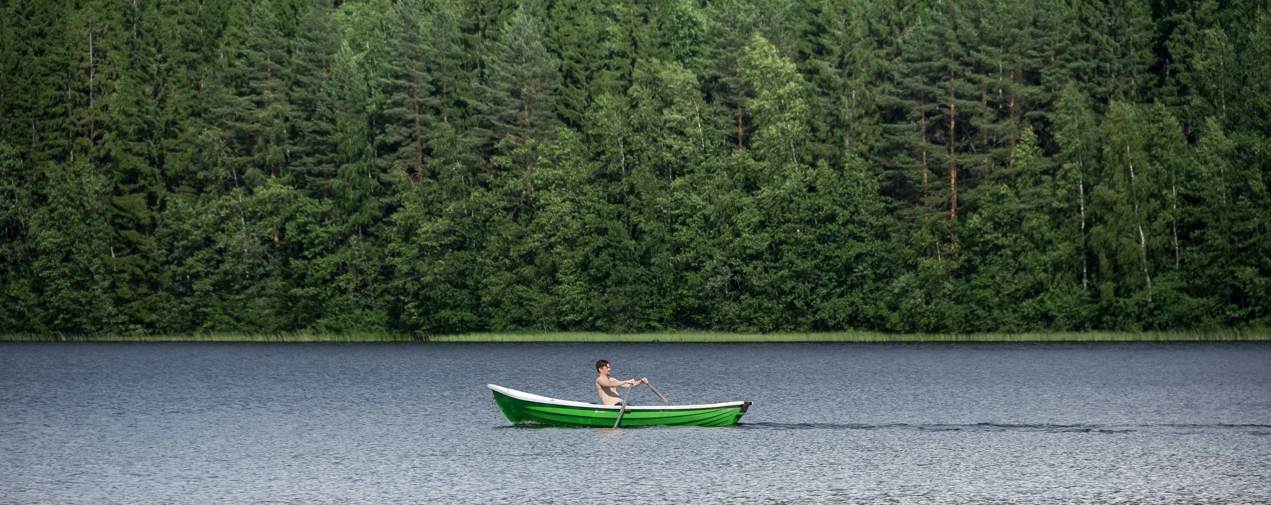 woman in blue shirt riding on green boat on river during daytime
